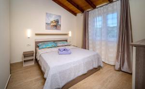 a bedroom with a bed with a purple towel on it at House Olive tree in Mundanije