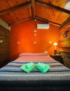 1 dormitorio con 1 cama y 2 toallas verdes en Aguada Escondida en San Marcos Sierras