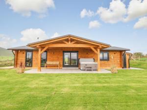 a log cabin with a grill in a yard at Bacheiddon Log Cabin in Machynlleth