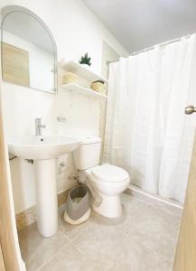 a white bathroom with a toilet and a sink at OASIS Punta Cana Apartment in Punta Cana