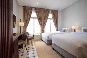 Postel nebo postele na pokoji v ubytování La Chronique Hotel