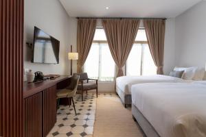 La Chronique Hotel tesisinde bir odada yatak veya yataklar