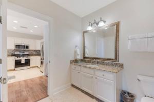 a white bathroom with a sink and a mirror at ELEGANT, COMFORTABLE, INEXPENSIVE... REUNION RESORT in Kissimmee