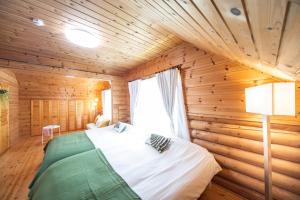 a bedroom with a bed in a wooden room at Awaji Large Log house in Goshiki in Sumoto