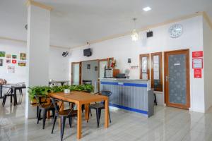 a dining room and kitchen with a table and chairs at RedDoorz near RS Islam Faisal Makassar in Makassar