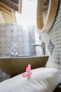 a pink ribbon sitting on top of a table in a bathroom at Java Wood in Gili Trawangan