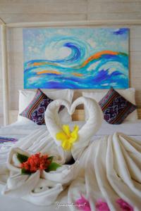 two swans making a heart on a bed at Java Wood in Gili Trawangan