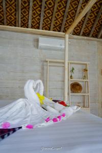 un cygne fait de fleurs sur un lit dans l'établissement Java Wood, à Gili Trawangan