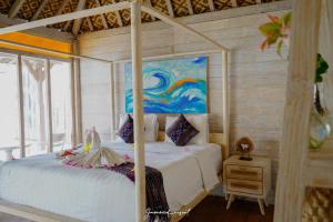 a bedroom with two beds and a painting on the wall at Java Wood in Gili Trawangan +37 photos