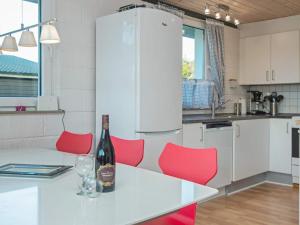 a kitchen with red chairs and a bottle of wine on a table at 6 person holiday home in Skjern in Skjern