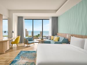 a hotel room with a bed and a living room at Holiday Inn Resort Ho Tram Beach by IHG in Ho Tram