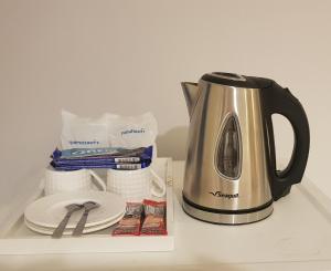 a tea kettle and some paper towels and a stack of plates at Sena House Lamlukka Klong2 in Pathum Thani