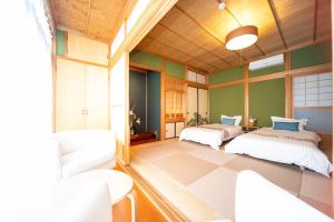 two beds in a room with green walls at Awaji egaosakuie tonouchi in Awaji