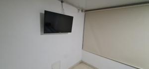 a tv hanging on a white wall in a room at Apartamento Ynj#2 in Bogotá