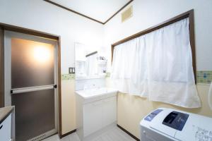 a bathroom with a sink and a washing machine at Awaji egaosakuie tonouchi in Awaji +56 photos