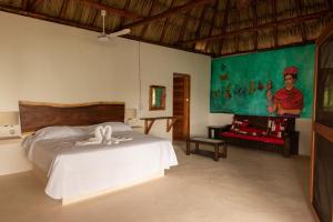 1 dormitorio con 1 cama y una pintura en la pared en Laguna Bacalar Ichkiichpan, en Santa Cruz Chico