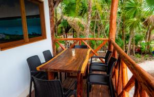 a wooden table and chairs on a balcony at Laguna Bacalar Ichkiichpan in Santa Cruz Chico