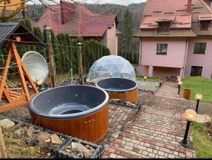 a large hot tub in a yard next to a house at Краса карпат in Yaremche