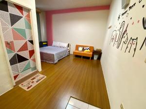 um quarto com uma cama e uma parede com arte em Happy Holiday Xiaoliuqiu em Xiaoliuqiu