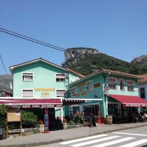 una calle con un edificio con una montaña en el fondo en Pensión Casa Corro en Carreña de Cabrales 