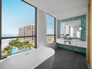 a bathroom with a tub and a view of the ocean at Holiday Inn Resort Ho Tram Beach by IHG in Ho Tram