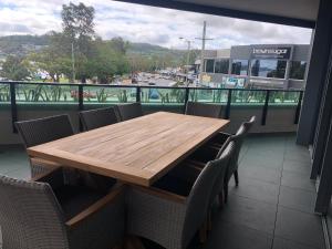 a wooden table and chairs on a balcony at Waters Edge Apartments in Warners Bay