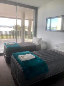 a hotel room with two beds and a balcony at Waters Edge Apartments in Warners Bay