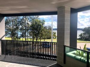 a balcony with a view of the water and trees at Waters Edge Apartments in Warners Bay