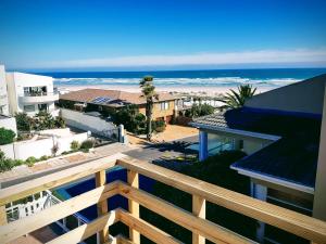 a view of the beach from the balcony of a house at Atlantic Loft - Open plan apartment with Sea Views in Melkbosstrand