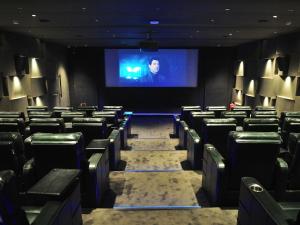 a stage with chairs and a screen in a theater at Seven Eleven Hotels and Club in Bhayandar