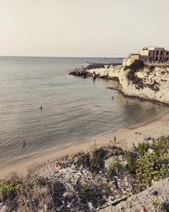 una playa con gente nadando en el agua en LA CHIOCCIOLA XX MIGLIA en Terrasini Favarotta