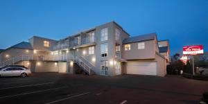 un edificio de apartamentos con un coche aparcado en un aparcamiento en Vita Nova Motel en Christchurch