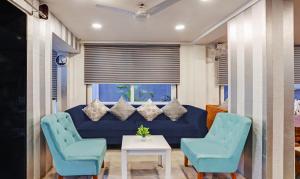 a living room with a blue couch and two chairs at Treebo Trend Finesta Suites, Nagpur Airport in Nagpur