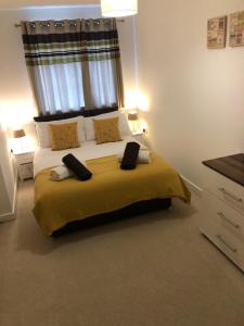 a bedroom with a large bed with yellow sheets and pillows at Apartment D102 in Kingsthorpe