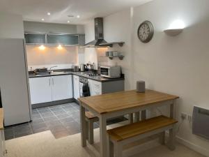a kitchen with a table and a clock on the wall at Apartment D102 in Kingsthorpe