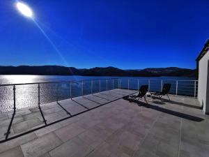 a deck with two chairs on a house with a view of the water at Lakeview-Estate ApartHotel in Staro Myasto
