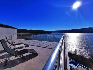 a deck with chairs and a view of the water at Lakeview-Estate ApartHotel in Staro Myasto