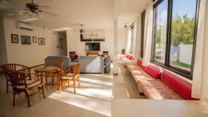 Villa Angelou - Sunlit Beach Getaway with Pool and WIFI في بيل مار: غرفة معيشة مع طاولة وكراسي وأريكة