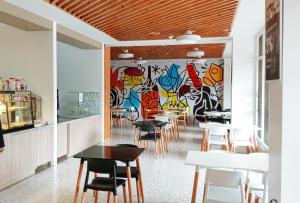 un restaurante con mesas y sillas y una pared de graffiti en Sans Hotel at The Luxebridge Suites Davao, en Davao City