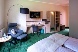 a hotel room with a bed and a desk and chairs at AKZENT Hotel Zur Post in Tabarz