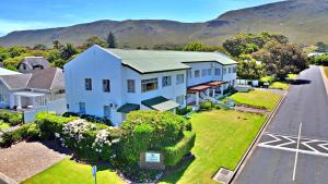 an aerial view of a white house with a church at Fairway Holiday Accommodation in Hermanus