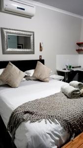 a bedroom with a bed with a mirror on the wall at De Dane Guestroom in Bloemfontein