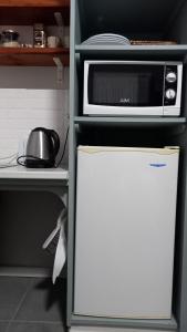 a microwave on top of a refrigerator in a kitchen at De Dane Guestroom in Bloemfontein