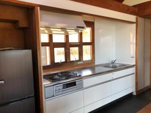 a kitchen with a sink and a stove top oven at Shiraishi Island International Villa in Kasaoka