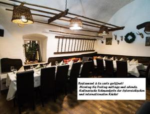 una sala da pranzo con tavolo, sedie e luci di Tennis Golf Hotel Höllrigl a Kottingbrunn