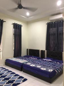 Ένα ή περισσότερα κρεβάτια σε δωμάτιο στο Homestay Cikgu Izan Kuala Terengganu