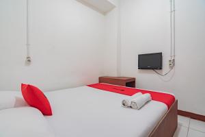 a bedroom with a bed and a tv on the wall at RedDoorz near Riau Junction Mall 2 in Bandung