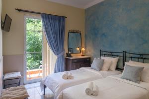 een slaapkamer met 2 bedden, een spiegel en een raam bij Marble House in Athene