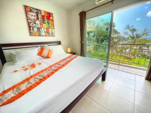 a bedroom with a bed and a large window at SR Sea View Apartments in Patong Beach