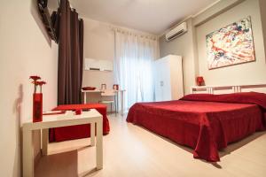 羅馬的住宿－羅馬的色彩酒店，一间卧室配有红色的床和一张桌子